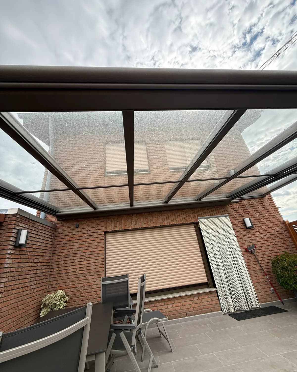 Verschmutztes Glasdach einer Terrassenüberdachung vor der Reinigung